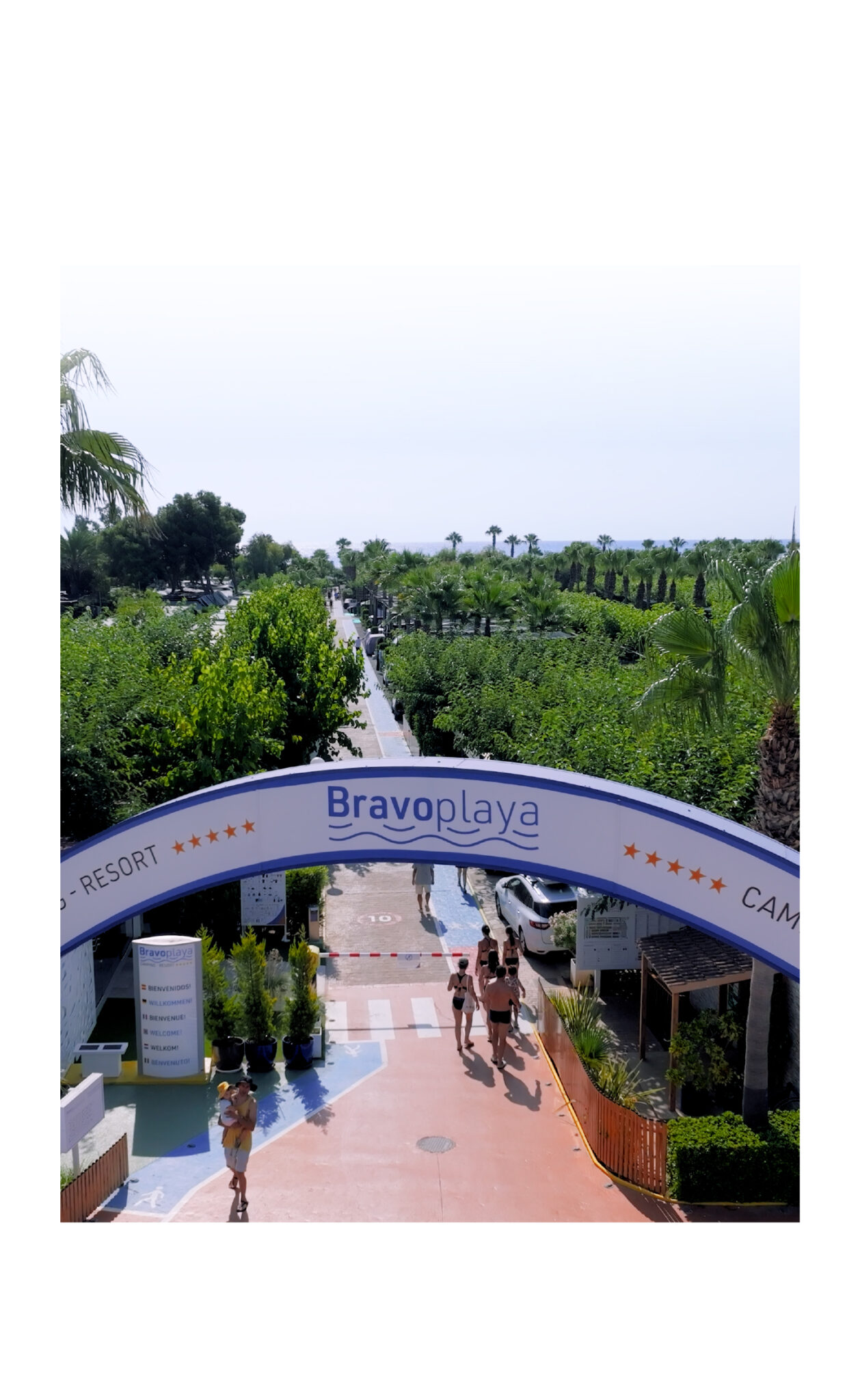 Bravoplaya resort entrance with palm trees and guests
