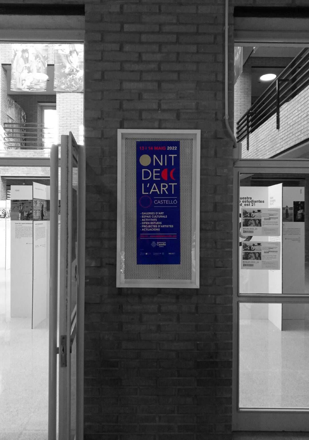 Art event poster on brick wall indoors