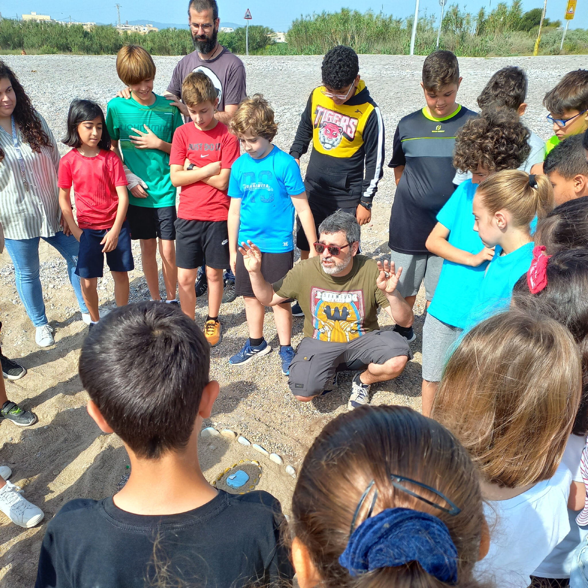 Instructor speaking to children outdoors on field trip