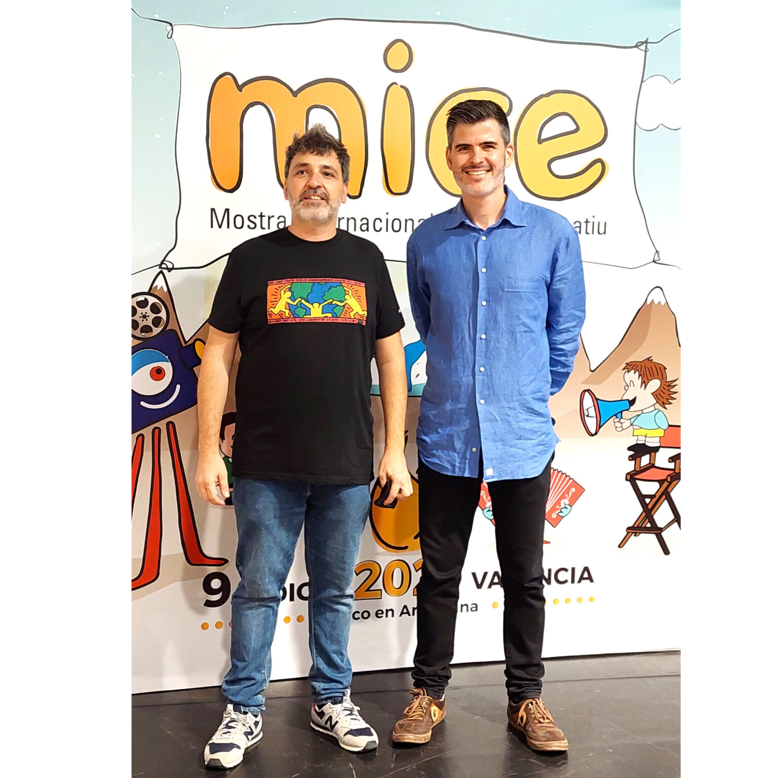 Two men posing at film festival backdrop
