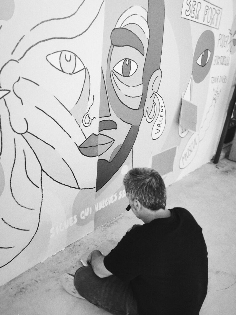 Artista pintando mural de rostro abstracto en pared